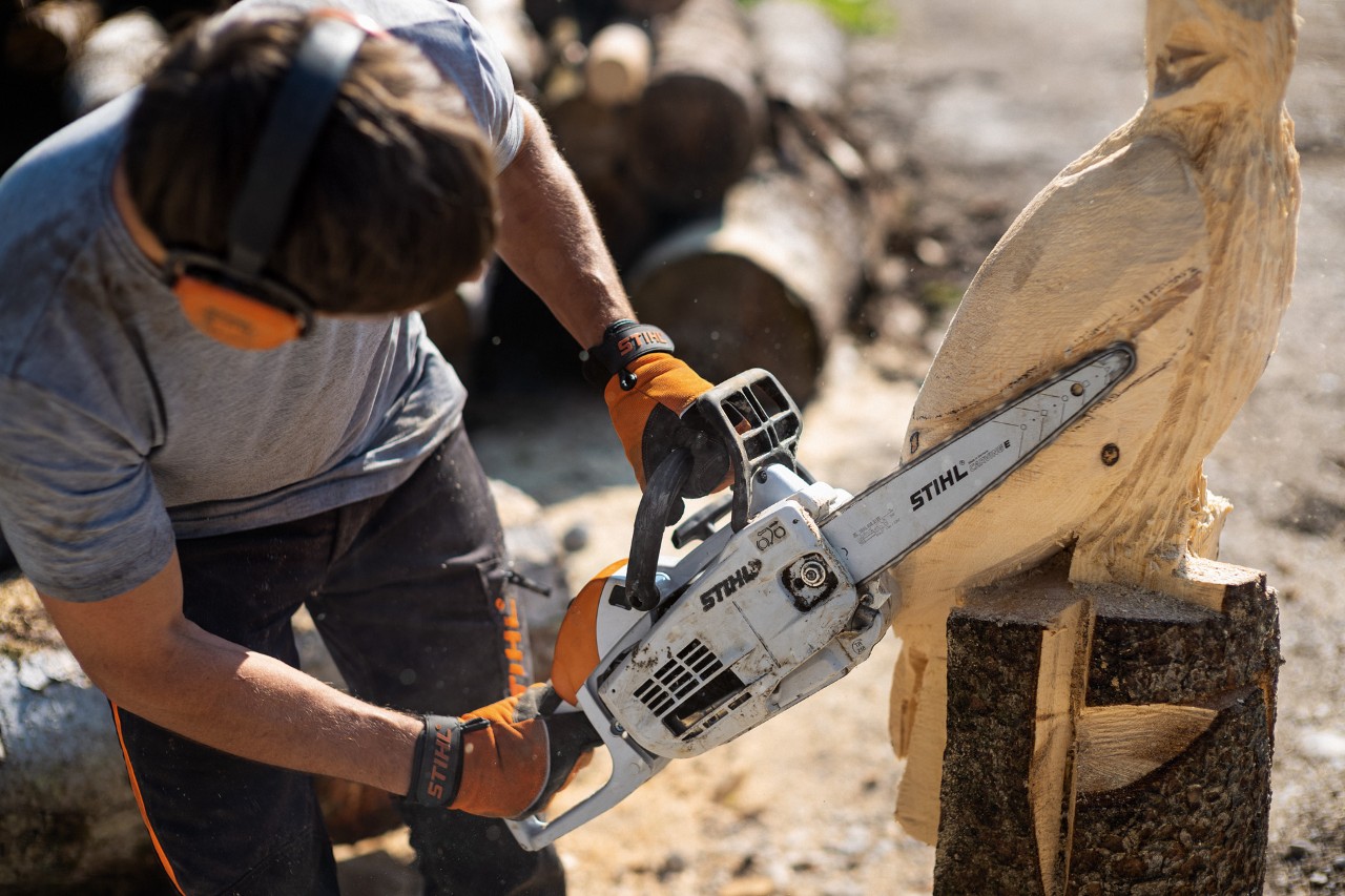 Mężczyzna rzeźbi sowę piłą łańcuchową STIHL