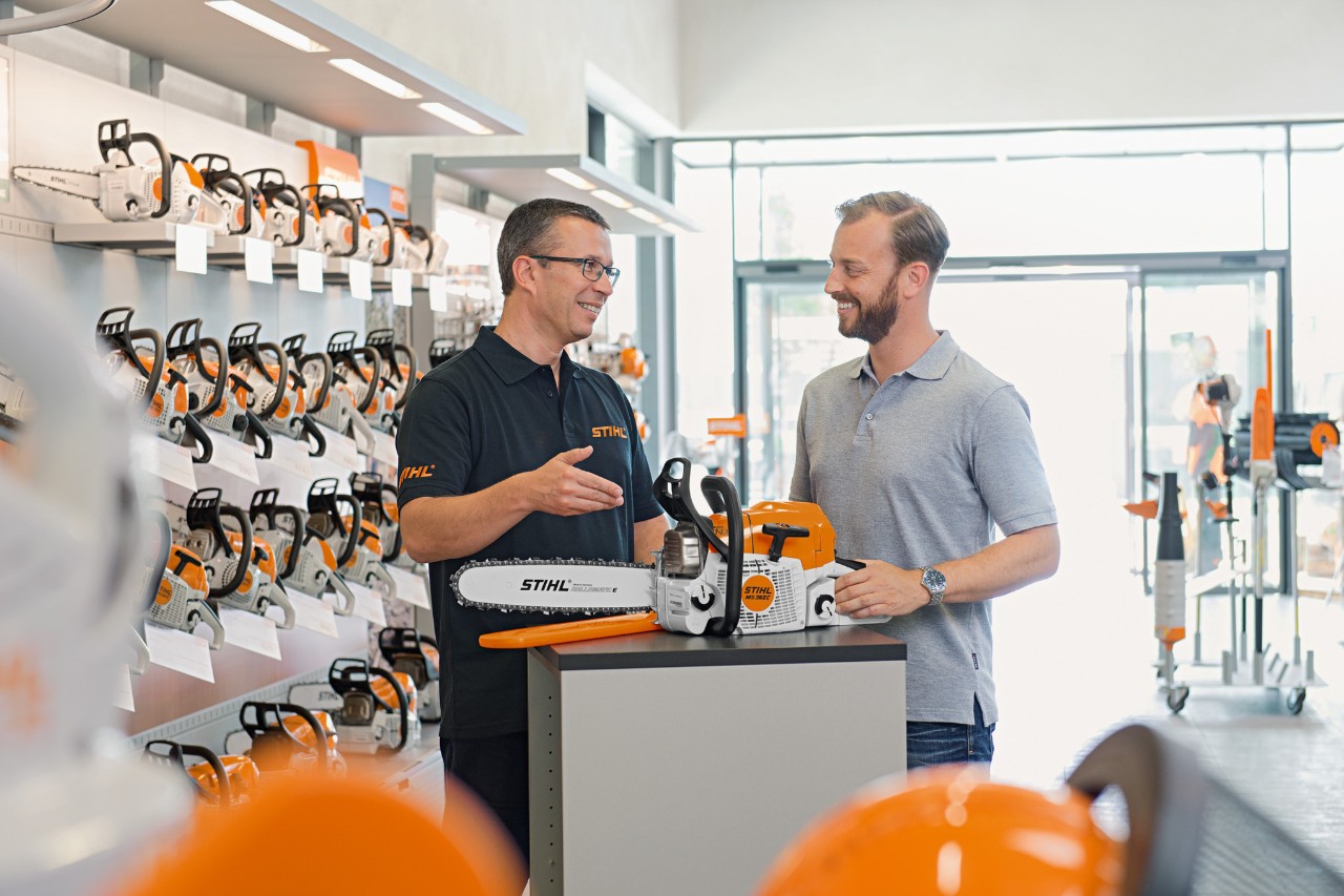 Dealer STIHL pomaga klientowi kupującemu pilarkę łańcuchową STIHL